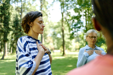 Женщины, практикующие осознанность и глубокое дыхание в природном парке - SeventyFour