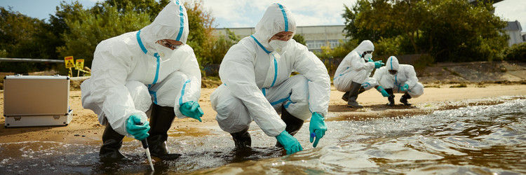 Группа ученых в защитных костюмах берет пробы воды на открытом воздухе - DragonImagesAsia