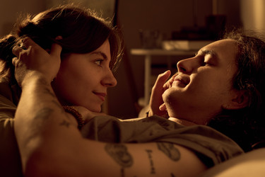 Любящая пара смотрит друг на друга и расслабляется в спальне у себя дома - Mediaphotos