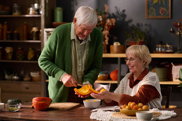 Пожилая пара вместе режет тыкву для осеннего ужина - Pressmaster