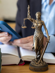 адвокат набирает сообщение на смартфоне возле статуи богини правосудия. онлайн-консультация - MyJule