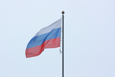 Российский флаг на фоне пасмурного неба - nkaup