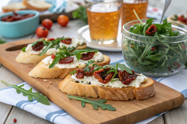 вкуснейшая брускетта с вялеными помидорами и свежей рукколой на деревянной доске - RomanZ