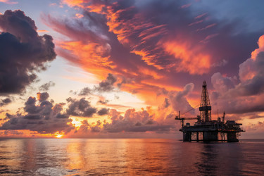 яркий закат над морской нефтяной вышкой с разноцветными облаками в сумерках - RomanZ