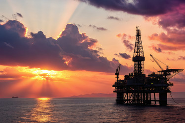 силуэт нефтяной вышки вырисовывался на фоне красочного заката над океаном - RomanZ
