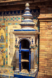 вертикальный вид колонны из декоративной керамической плитки между нишами провинциальных скамеек на площади испании в севилье - joseh51
