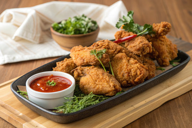 вкусная жареная курица подается с соусом и свежей зеленью на деревянном столе - RomanZ