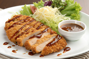 хрустящая куриная котлета подается со свежим салатом и соусом на белой тарелке - RomanZ