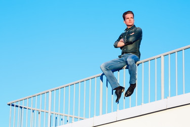 Young man in denim clothes sits with his arms - paha_l