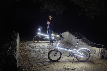 Woman with cell phone stands at night park near - paha_l