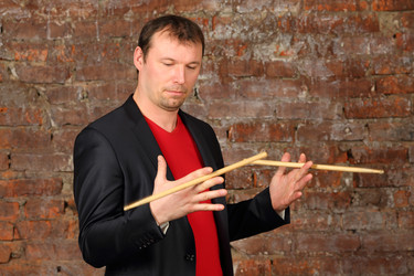 Man in black jacket plays sticks in retro studio - paha_l