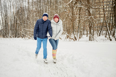 Smiling woman and man skate at ice pathway in - paha_l