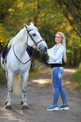 Woman with white hair stands near white horse in - paha_l