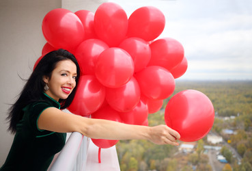 Woman in green dress holds many red balloons and - paha_l