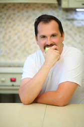 Happy man with mustache in white bites green apple - paha_l