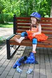 Little girl sits on bench and removes roller - paha_l