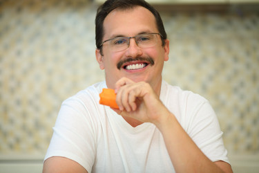 Happy handsome man in glasses eats orange carrot - paha_l