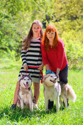 Mother and daughter along with two dogs in park on - paha_l