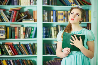 Young woman in green dress stands at library - paha_l