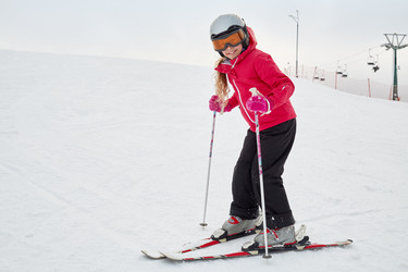 Smiling teenage girl equipped for skiing on snowy - paha_l