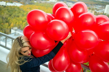 молодая женщина с длинными светлыми волосами держит в руках красные - paha_l
