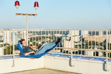 Young man in denim clothes lies in hammock mounted - paha_l