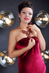 Beautiful woman poses in red dress near wall with - paha_l