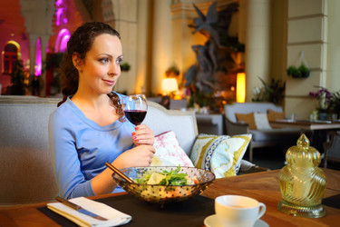 Woman holds glass with wine, smiles and drinks in - paha_l