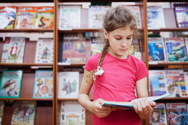 Little girl stands reading book in the hall of - paha_l