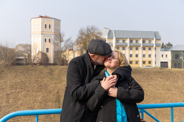 романтическая зрелая пара обнимается, мужчина целует женщину в щеку - AliakseiSmalenski