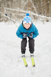 Teenage boy skis at snowy lawn in winter park - paha_l