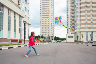 Girl in red jacket and blue jeans let kite on - paha_l