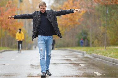 молодой человек в черной куртке идет по аллее в парке, - paha_l