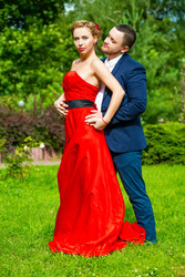 Man in suit and young woman in red dress pose on - paha_l