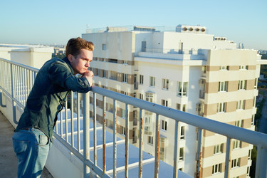 Young man in denim clothes stands on the building - paha_l