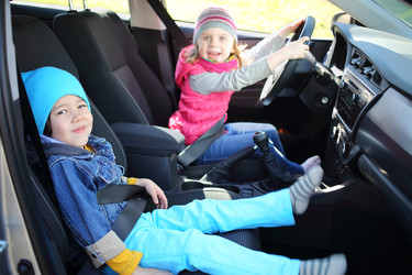 Happy young children - boy and girl playing in car - paha_l