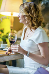 Curly woman in white drinks red wine in cozy - paha_l