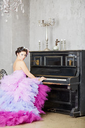 Woman in fluffy purple dress sits on piano-stool - paha_l