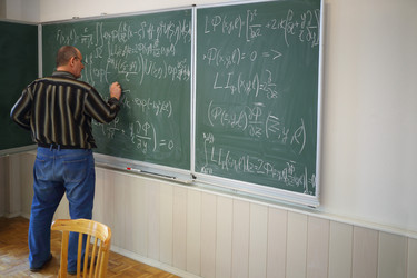 Teacher writes mathematics formulas on blackboard - paha_l