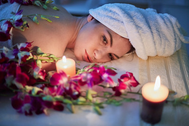 Woman lies on couch with flowers lit by two - paha_l