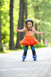 Little cute girl in skirt and helmet roller skates - paha_l