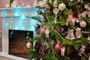 Decorated Christmas firtree near fireplace in room - paha_l