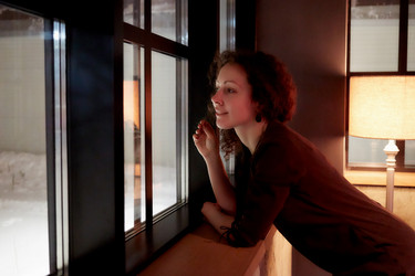 Young curly woman looks in window leaning her - paha_l