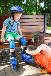 Little cute boy sits on bench and girl helps to - paha_l