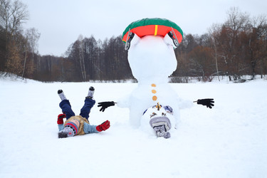Boy lies near upside down snowman with snowtube at - paha_l