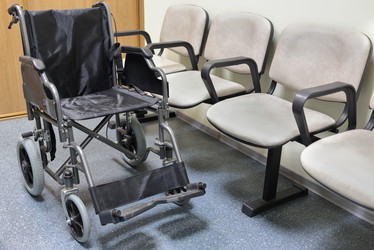 Wheel chair stands in lobby of hospital ready to - paha_l
