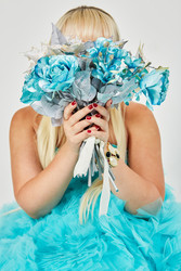 Woman in blue fluffy dress hides her face behind a - paha_l