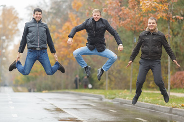 Three young men in black jackets jumping for fun - paha_l