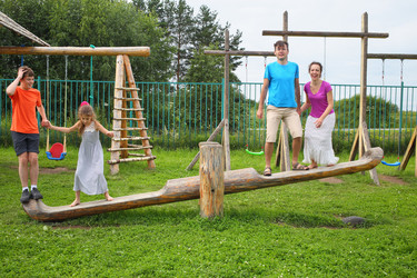 Happy parents with son and daughter jumping on a - paha_l