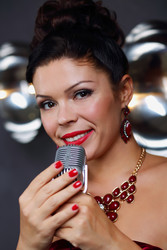 Pretty girl singer poses with microphone near wall - paha_l